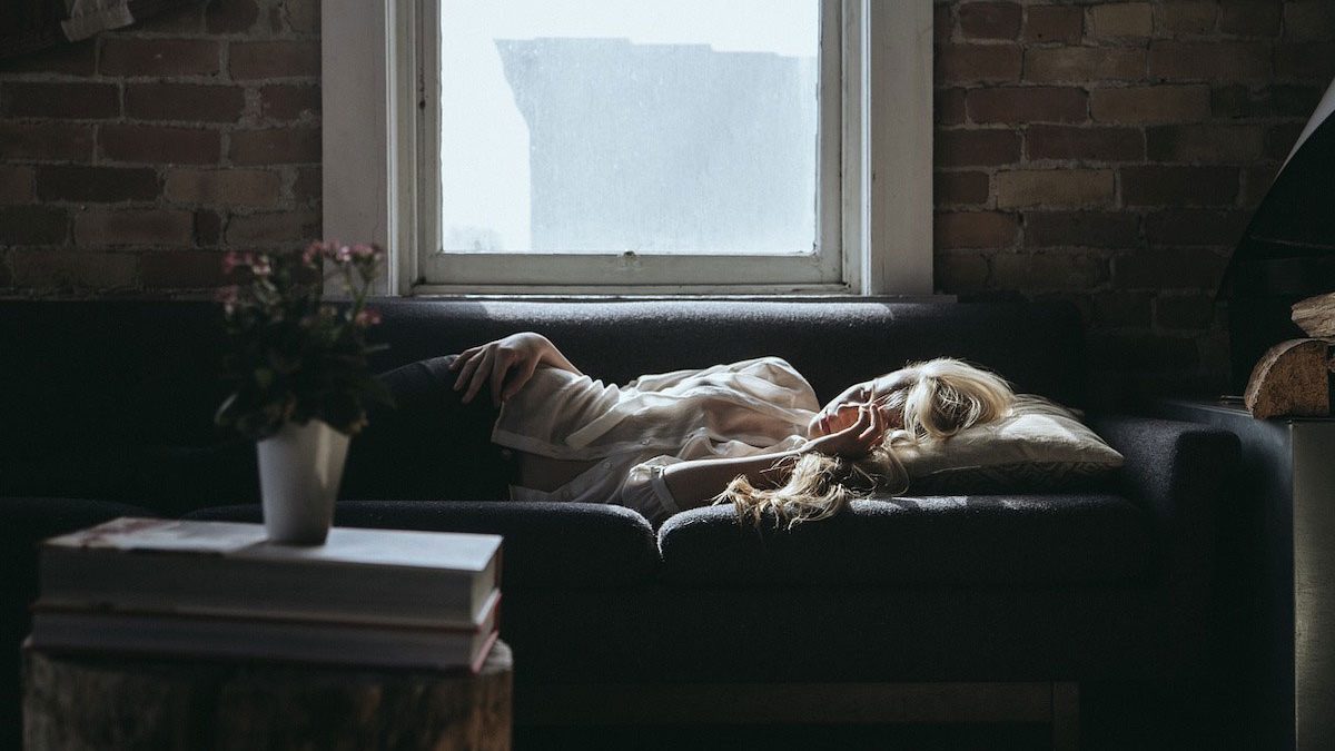 Jeune femme épuisée, dormant dans son canapé