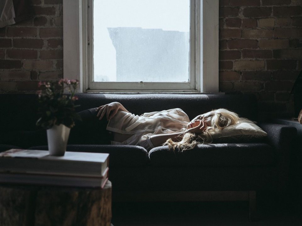 Jeune femme épuisée, dormant dans son canapé
