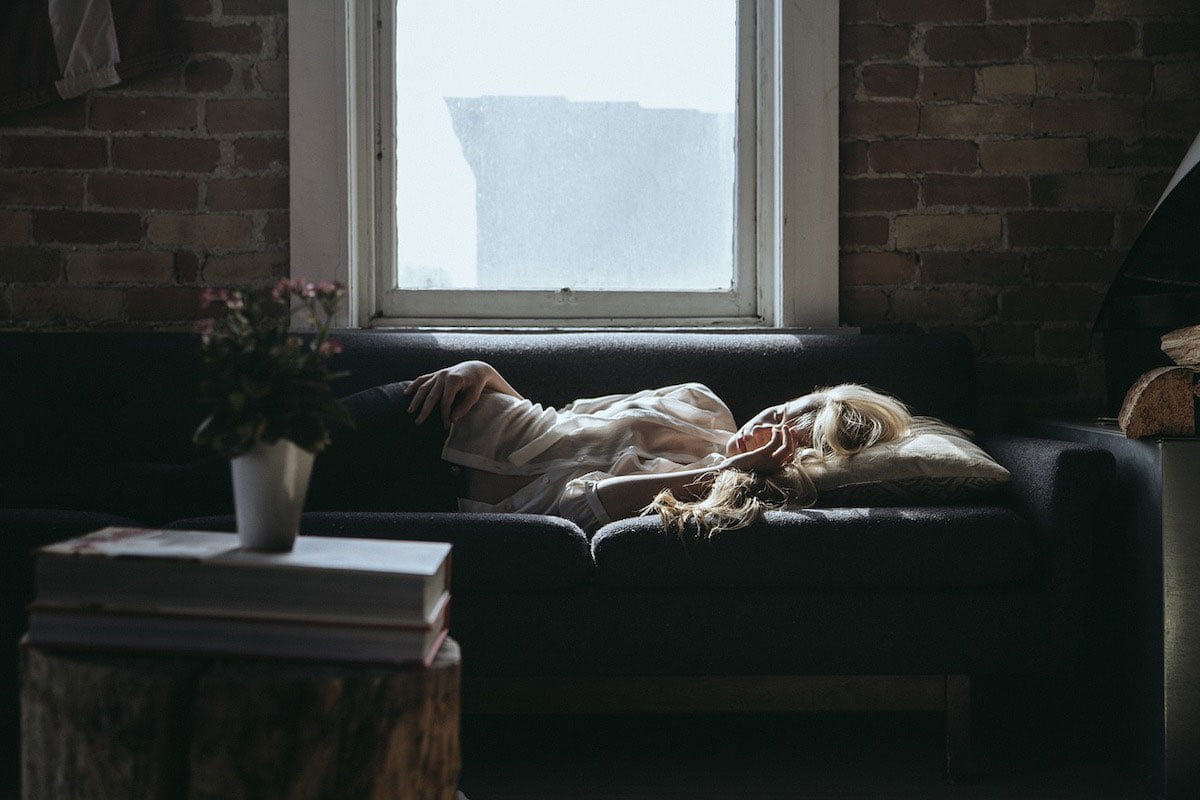 Jeune femme épuisée, dormant dans son canapé