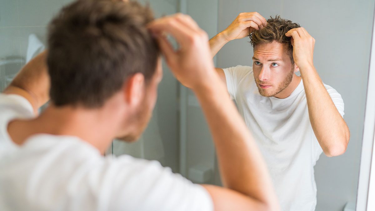 Homme constatant qu'il perd ses cheveux